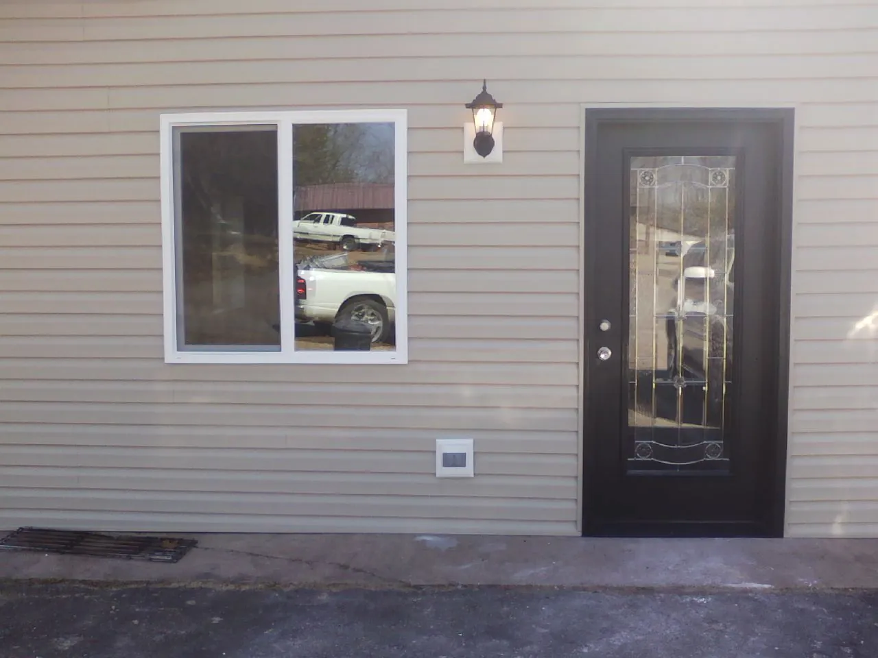 New siding, window and entry door on the side of an addition in Driftwood